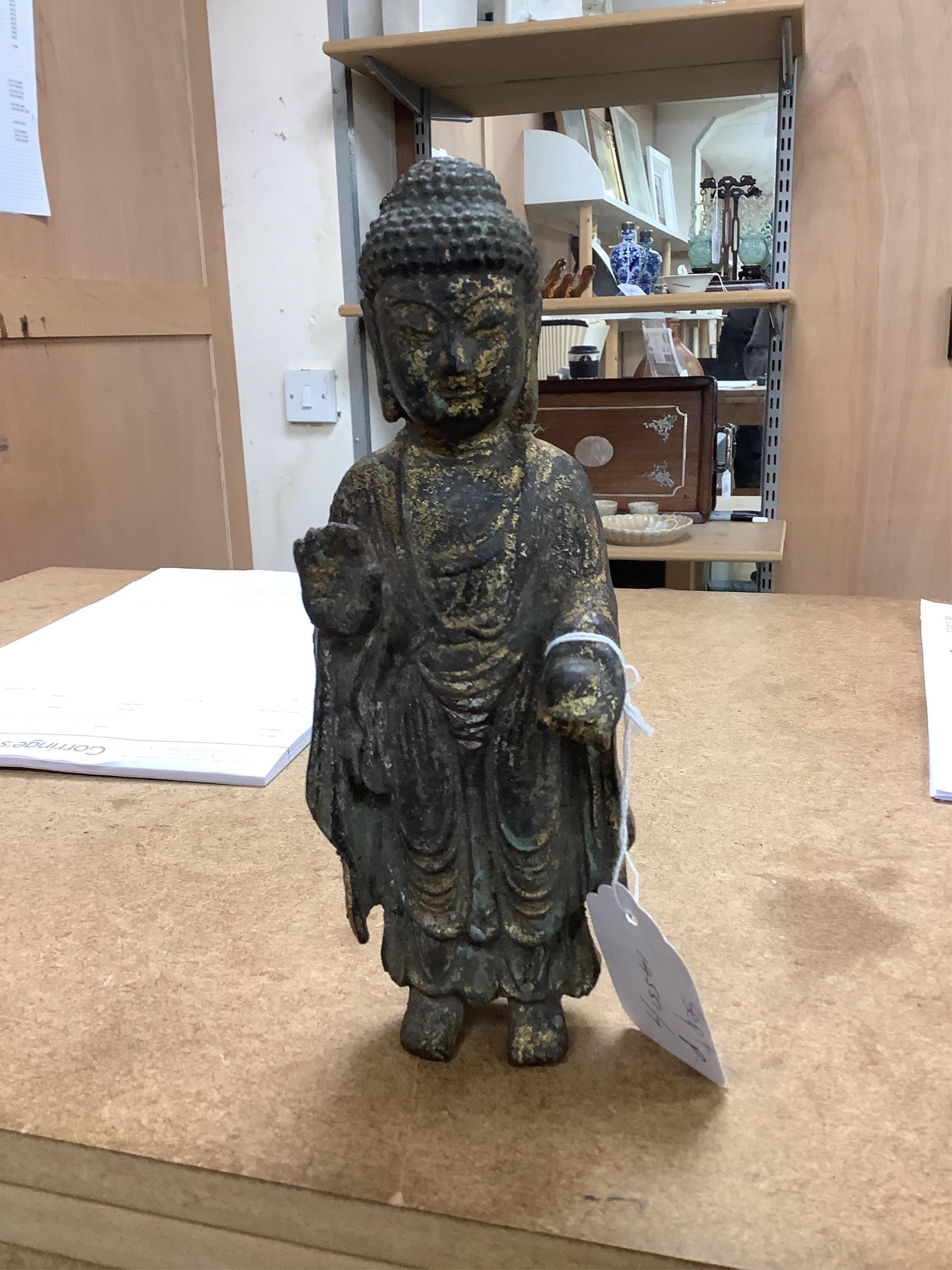 A Chinese gilt bronze model of a standing Buddha, 21.5cm. Condition - poor to fair